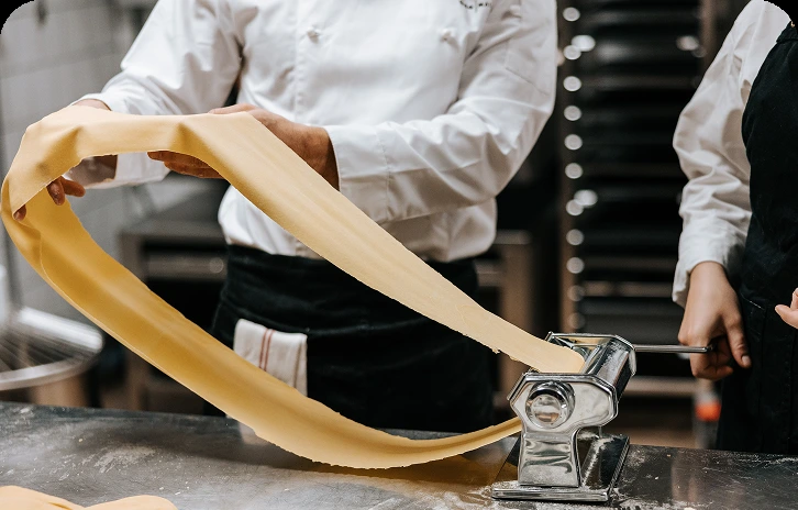 Deltagare lagar pasta under en matlagningsaktivitet